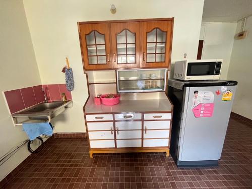 a small kitchen with a refrigerator and a microwave at ห้องเช่ารายวัน เมืองทองธานี C5 By ณดา in Ban Bang Phang