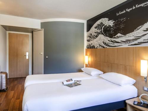 En eller flere senge i et værelse på IBIS Cannes Mouans Sartoux Piscine parking gratuit