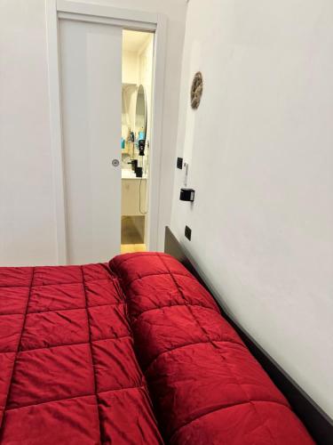 a bedroom with a red comforter on a bed at Spago rooms 2 in Vieste