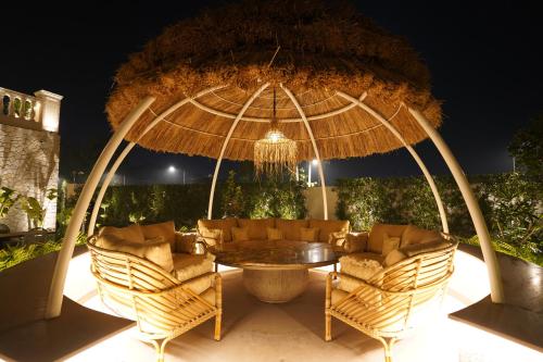 a patio with a table and chairs under a large umbrella at Kazan in Amritsar