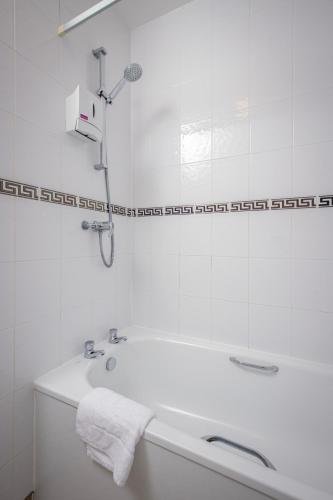 a white bathroom with a tub and a sink at Ashley Victoria in Blackpool