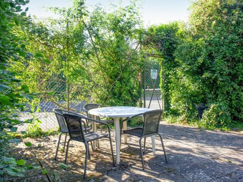 a table with two chairs and a white table and chairs at The Stables in Clyst Saint Mary