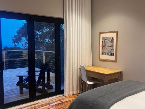 a bedroom with a bed and a desk and a window at 2 on Fairview in Kloof