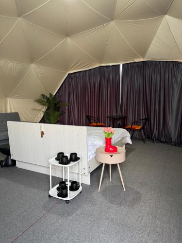 a tent with a bed and a table with shoes on it at Issyk-Kul Glamping in Chon-Sary-Oy