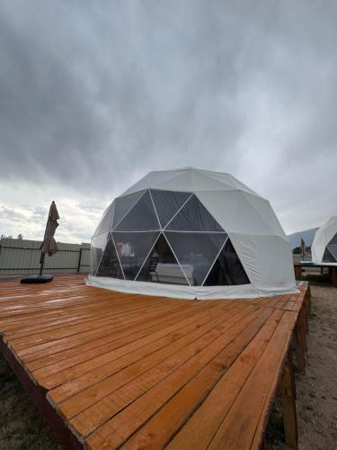 a tent on top of a wooden deck at Issyk-Kul Glamping in Chon-Sary-Oy
