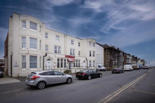 a street with cars parked in front of a building at Ashley Victoria in Blackpool