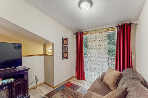 a living room with a couch and a large window at Peaceful Creekside in Orick
