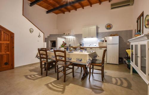 eine Küche mit Tisch und Stühlen und einem Kühlschrank in der Unterkunft Stunning Home In Trappeto With Wifi in Trappeto