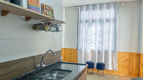 eine Küche mit Spüle und Fenster in der Unterkunft Casa térrea geminada aconchegante AV3402 in Higienópolis
