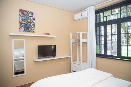 ein Schlafzimmer mit einem Bett, einem Fernseher und einem Fenster in der Unterkunft Casa térrea geminada aconchegante AV3402 in Higienópolis