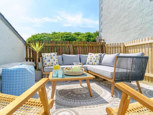 a patio with a couch and chairs and a table at Y Graiglwyd in Amlwch