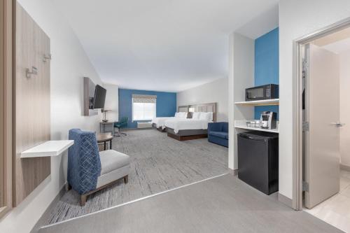 a hotel room with a bed and a living room at Holiday Inn Express and Suites Granbury by IHG in Granbury
