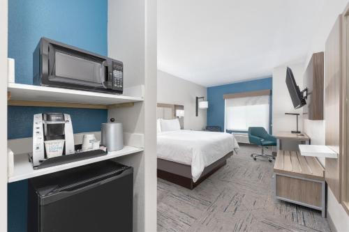 a hotel room with a bed and a tv at Holiday Inn Express and Suites Granbury by IHG in Granbury