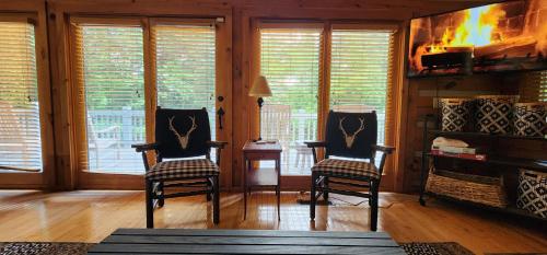 a living room with two chairs and a fireplace at The Bigwitch Cabin in Cherokee