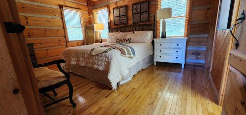 a bedroom with a bed and a chair in a cabin at The Bigwitch Cabin in Cherokee
