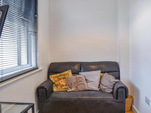 a brown leather couch in a room with a window at Palm Court in Bournemouth