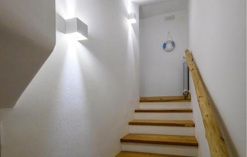 a stairway with white walls and wooden stairs at Beautiful Home In Porto Potenza Picena in Porto Potenza Picena