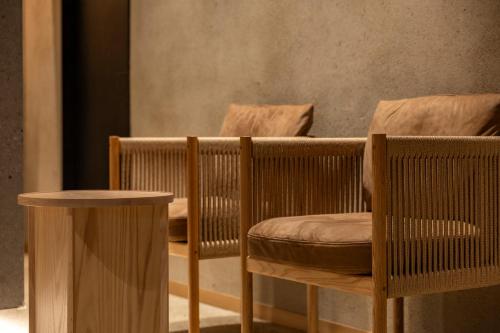 a room with two wooden chairs and a table at soyo-ne kyoto sanjo in Kyoto