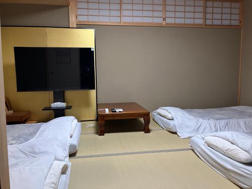 a room with two beds and a flat screen tv at マリーナベイCentral in Atami