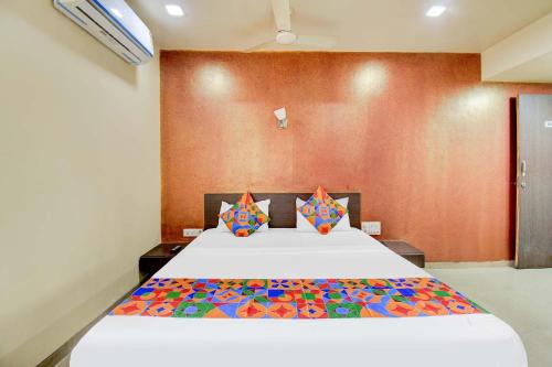 a bedroom with a large bed with colorful pillows at FabExpress Sun n Shine in Pune