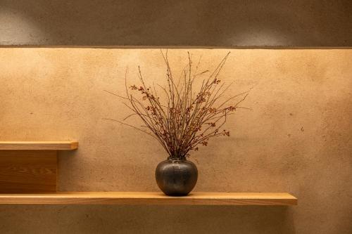 a vase with a plant in it sitting on a shelf at soyo-ne kyoto sanjo in Kyoto