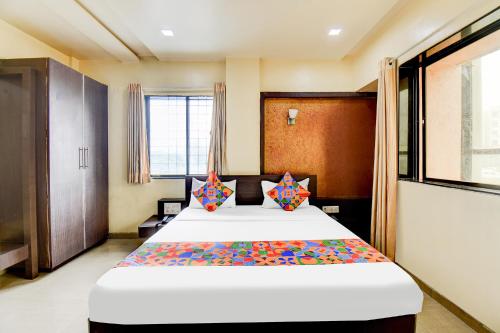 a bedroom with a large bed with colorful pillows at FabExpress Sun n Shine in Pune