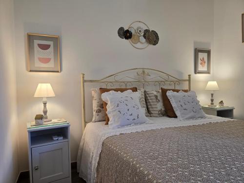 une chambre avec un lit avec des oreillers et deux lampes dans l'établissement A casa di Isor, à San Vito dei Normanni