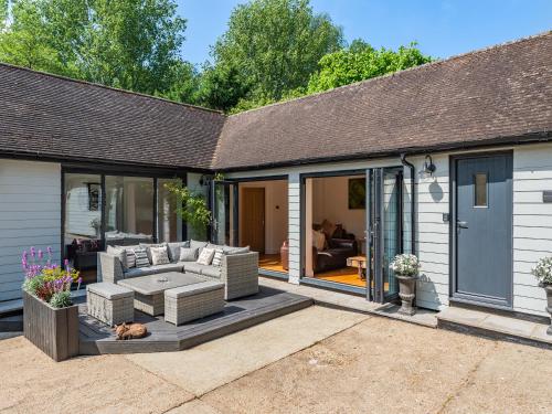 a house with a patio with a couch and windows at Foxton Lodge - Uk47296 in Harrietsham