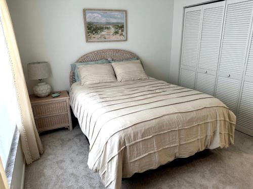 a bedroom with a bed and a night stand with a lamp at Coastal Escape in Bonita Springs
