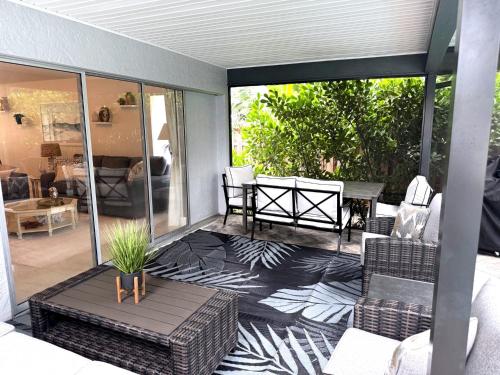a screened in porch with chairs and a table at Coastal Escape in Bonita Springs