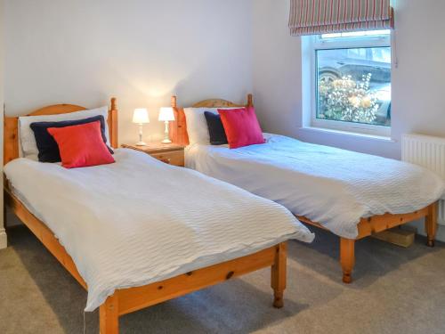 two twin beds in a room with a window at Clarksburn Blue in Monreith