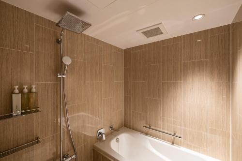 a bathroom with a shower and a bath tub at soyo-ne kyoto sanjo in Kyoto