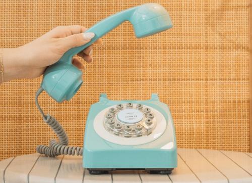 a person holding a blue phone in their hand at Ridley House - Key West Historic Inns in Key West