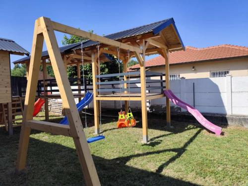a wooden play structure with slides and swings at Vila Homoljska Idila1 Banja Zdrelo in Petrovac na Mlavi