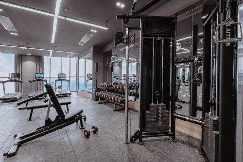a gym with treadmills and machines in a building at Coastal Charm Panorama Bayview in Nha Trang