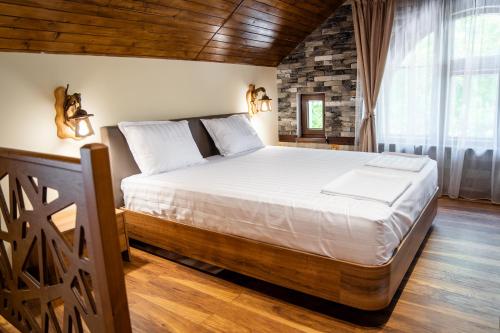 ein Schlafzimmer mit einem großen Bett in einem Zimmer in der Unterkunft Къща за гости Фамилия Бешкови in Vratsa