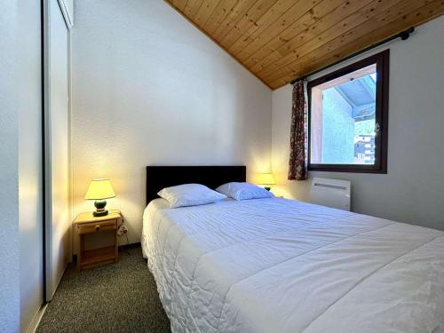 a bedroom with a large white bed with a window at Chalet en Duplex 10 Pers. avec Terrasse/Jardin, Proche Pistes – La Salle les Alpes - FR-1-330F-3 in La Salle Les Alpes