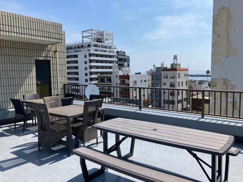 a patio with tables and chairs on a balcony at マリーナベイCentral in Atami