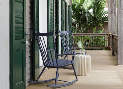 two black chairs on a porch with a green door at Ridley House - Key West Historic Inns in Key West