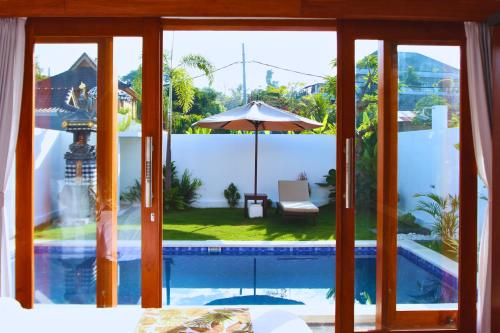 Habitación con ventanas y vistas a la piscina. en Wisesa Lovina Villa, en Lovina