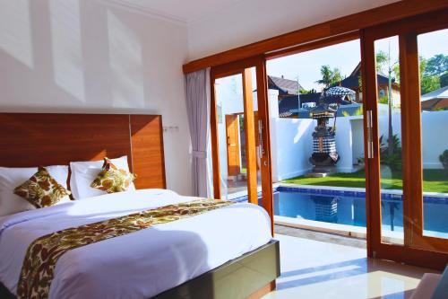 a bedroom with a bed and a view of a pool at Wisesa Lovina Villa in Lovina