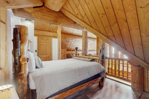 Un dormitorio con una cama en una habitación con techos de madera. en Mogul Hill Cabin, en Sandpoint