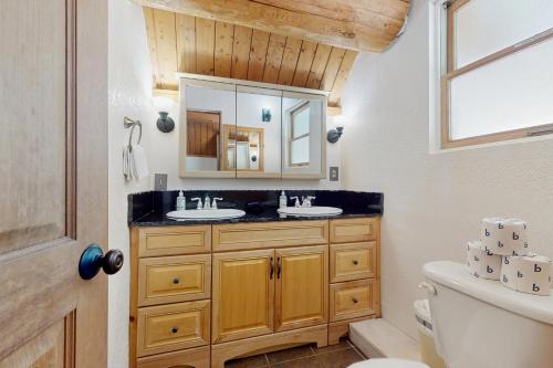 Un baño con dos lavabos y un espejo. en Mogul Hill Cabin, en Sandpoint