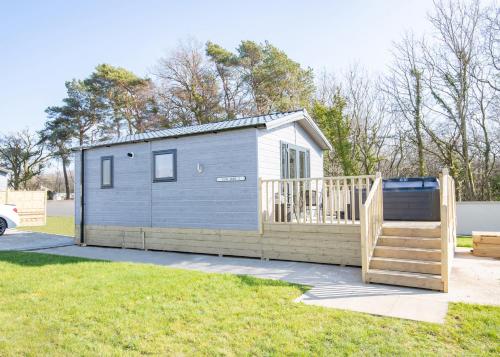 a tiny house with a porch and a deck at Arran Hills in Kilwinning