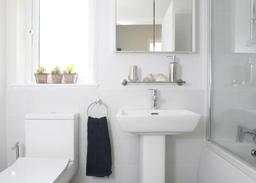 a white bathroom with a sink and a mirror at Clear Sky Lodge Park in Falstone