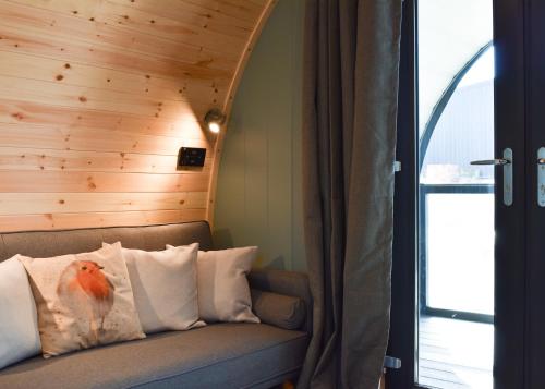 a room with a couch with a bird on the pillow at Hill Farm Retreat in Wangford