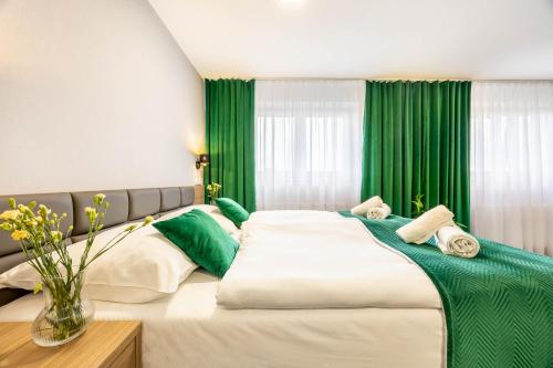 a bedroom with a large bed with green curtains at Hotel Polonia Centrum in Wrocław