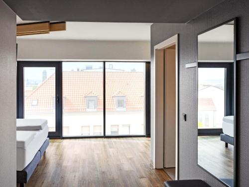 a room with two beds and a large window at B&B HOTEL Fulda-Hbf in Fulda