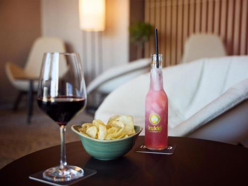 a glass of wine and a bowl of chips on a table at B&B HOTEL Fulda-Hbf in Fulda