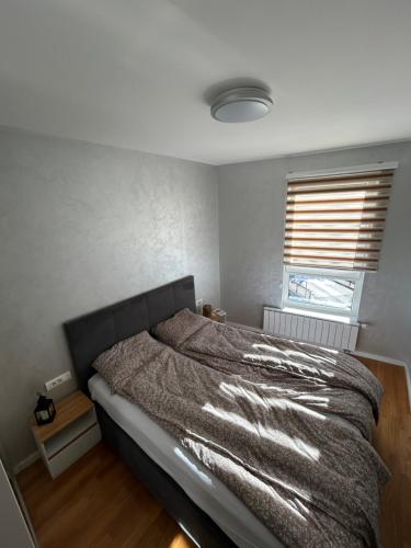 a bedroom with a bed and a window at CENTRAL POINT APARTMENT - City centar Zenica- in Zenica